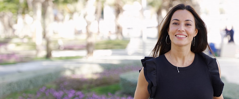 woman smiling, her hair blowing in the wind