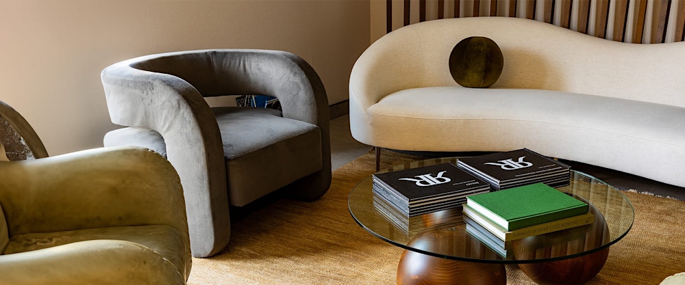 fabric sofa and chairs near a glass coffee table