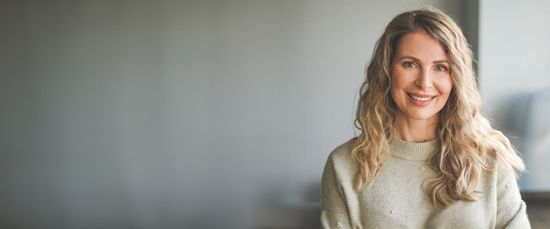 woman with blonde wavy hair smiling