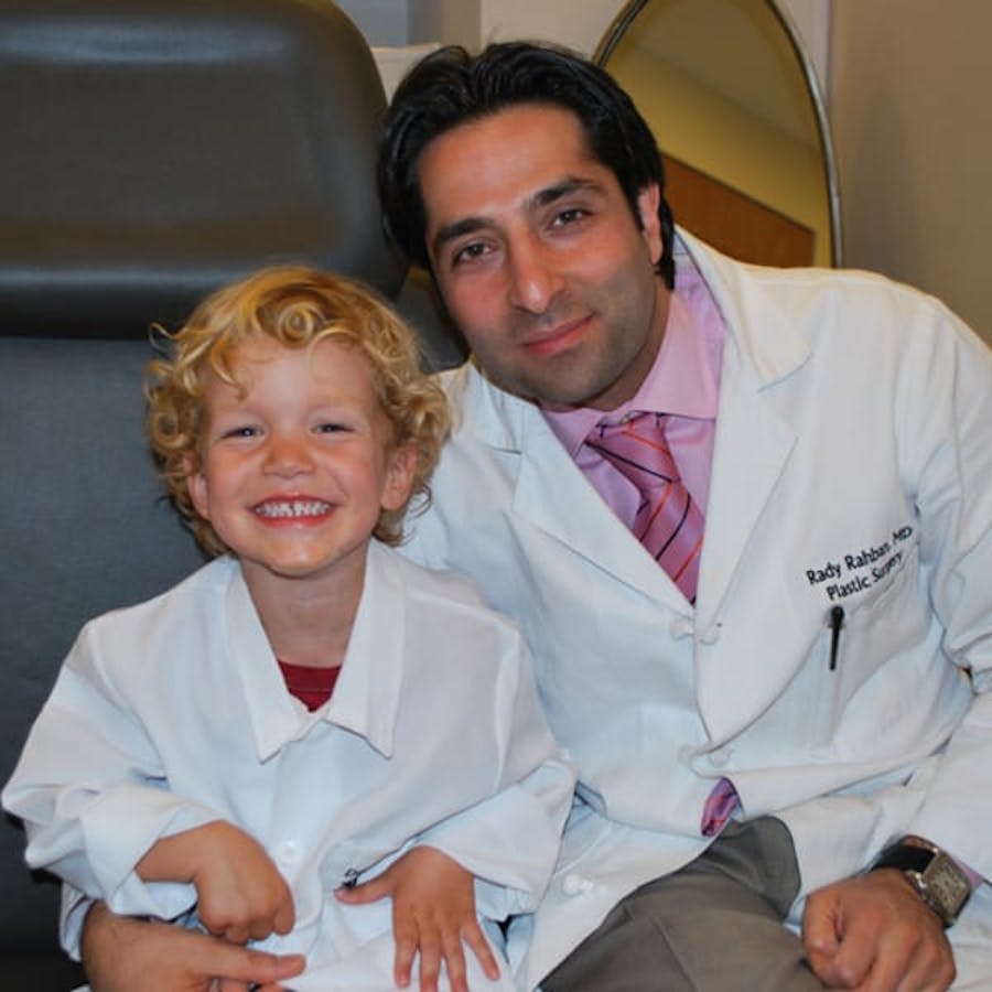 Dr. Rahban smiling with a pediatric patient