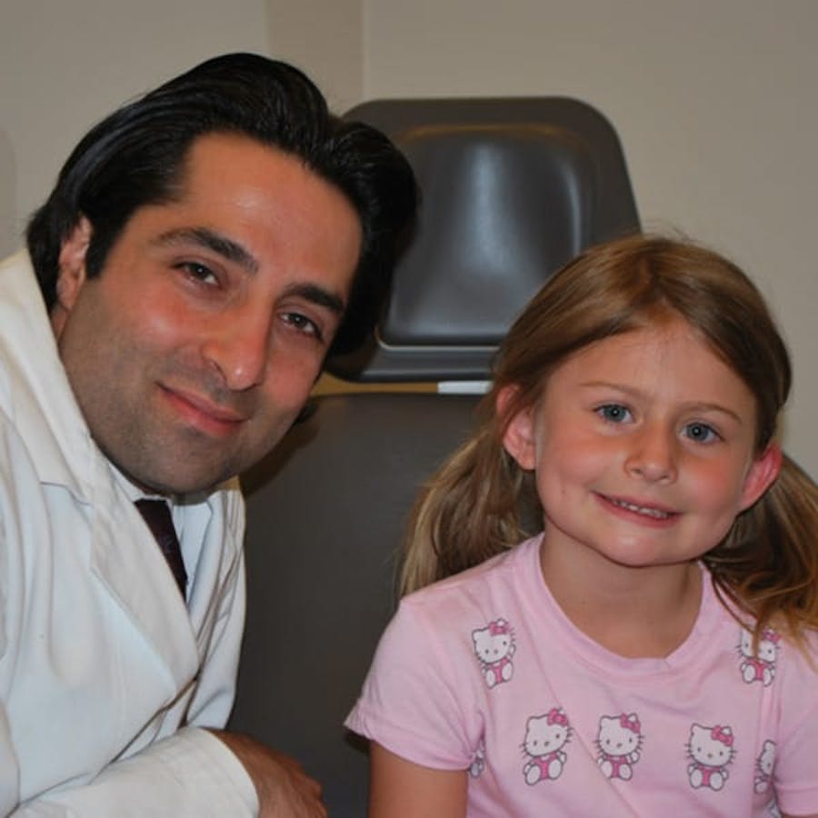 Dr. Rahban smiling with a pediatric patient