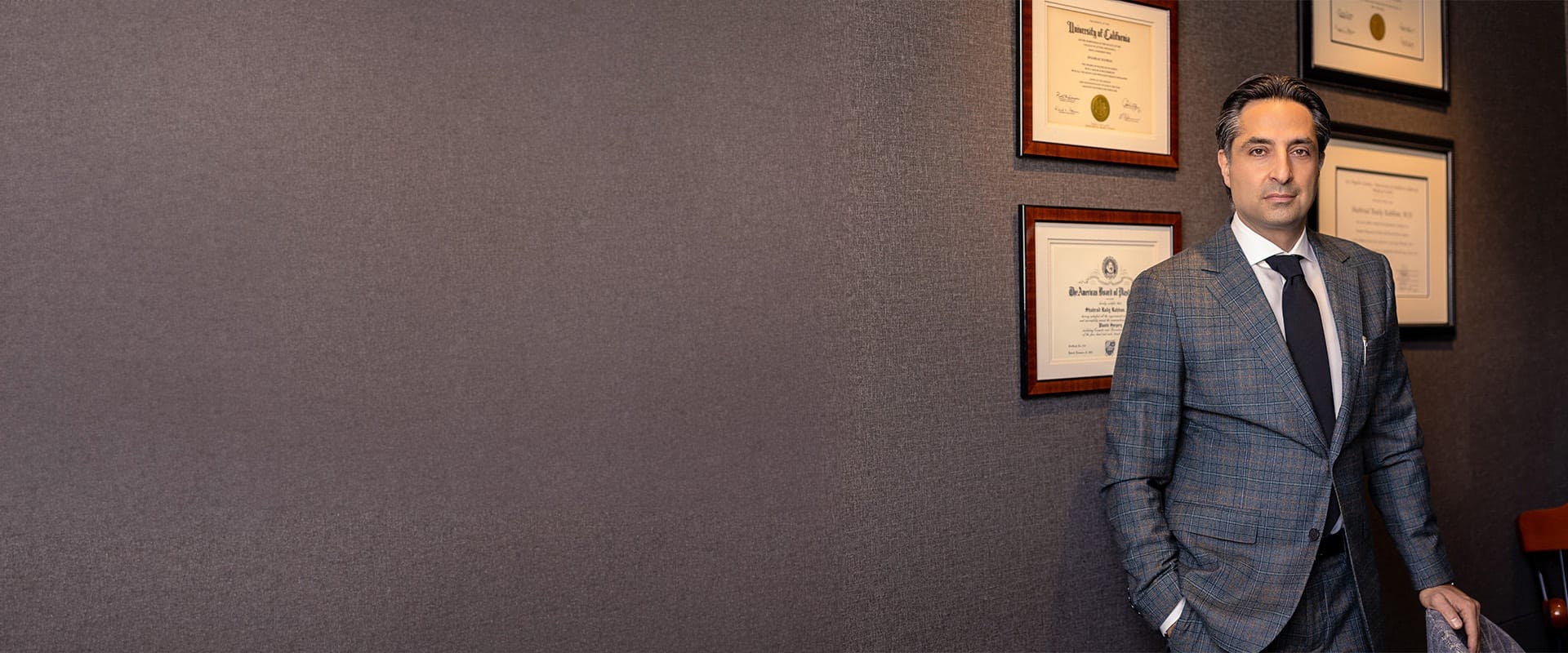 Dr. Rahban standing in front of a wall