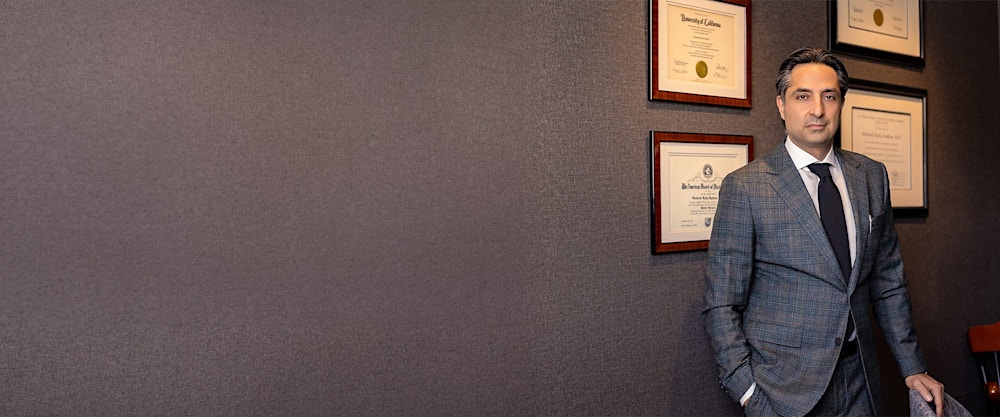 Dr. Rahban standing in front of a wall