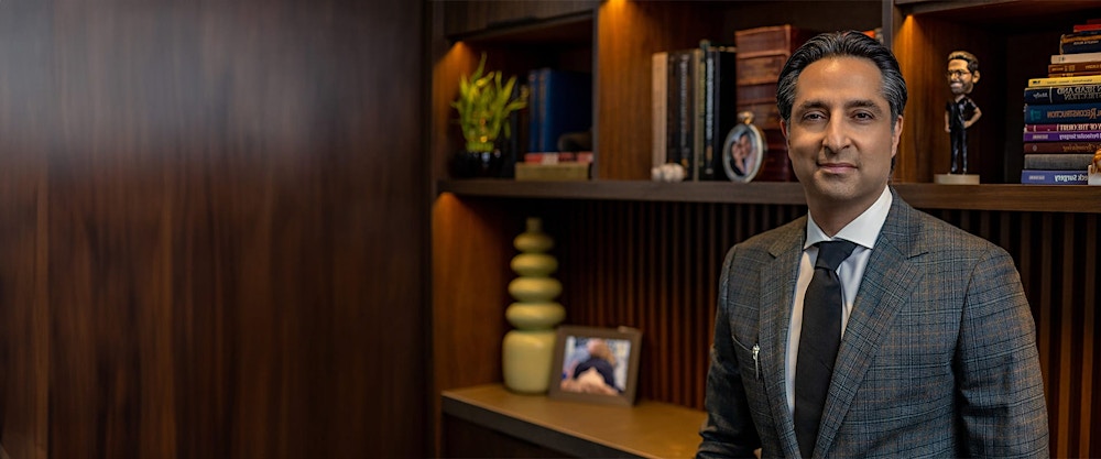 Dr. Rahban standing in front of a bookcase
