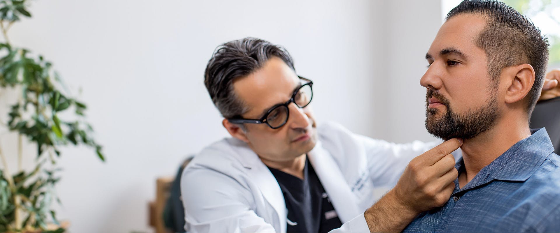 Dr. Rahban touching a patient's chin