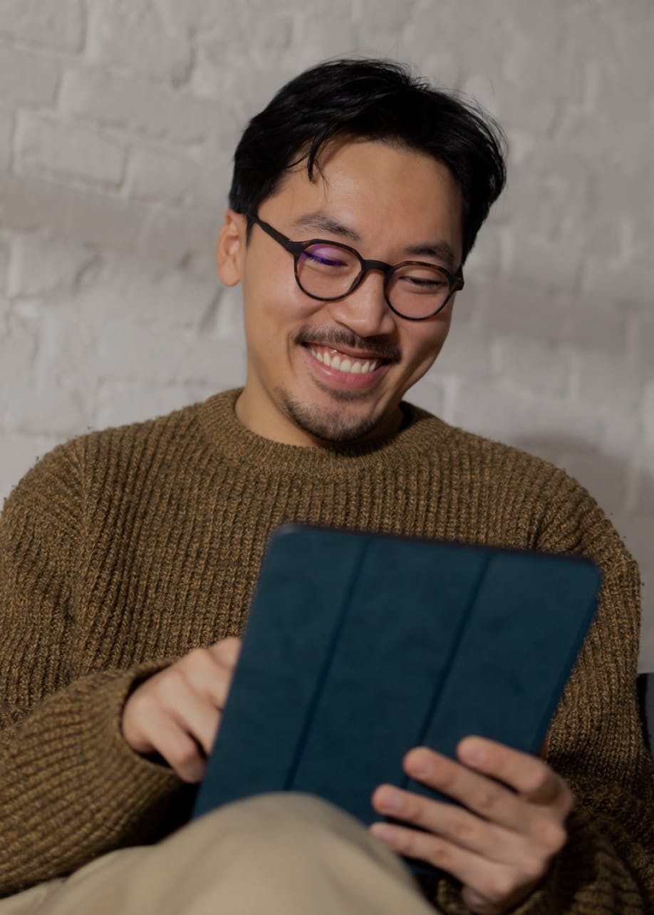 Smiling man with glasses on a tablet