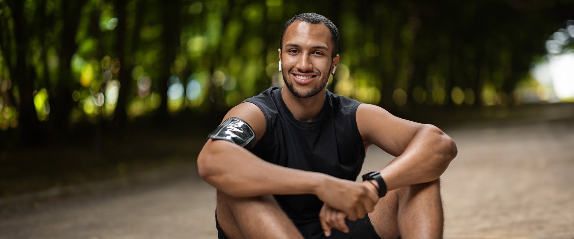 Man in workout attire sitting and smiling