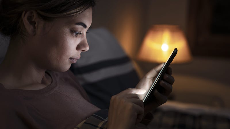 woman looking at phone screen in dark room