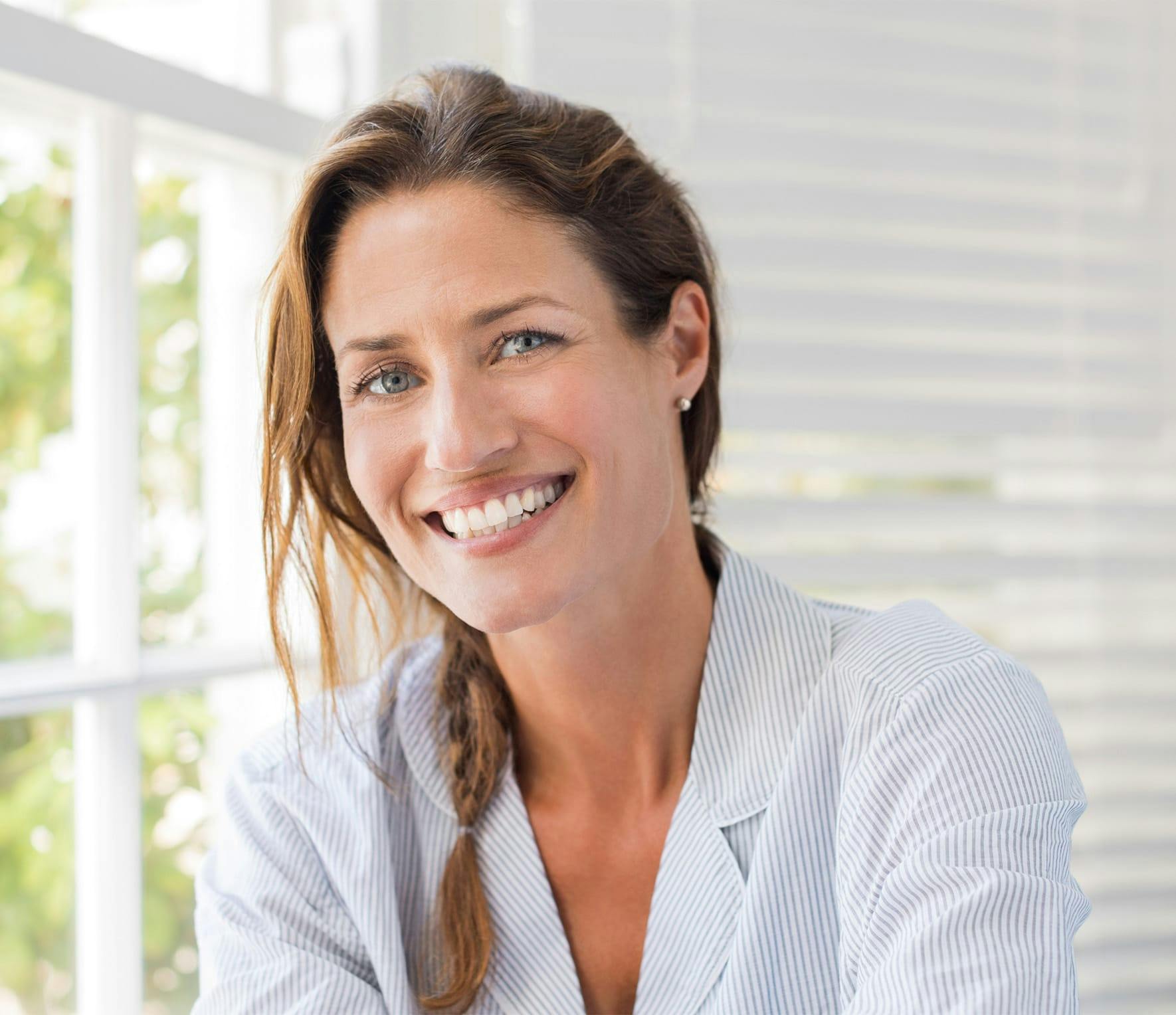 Woman smiling near window