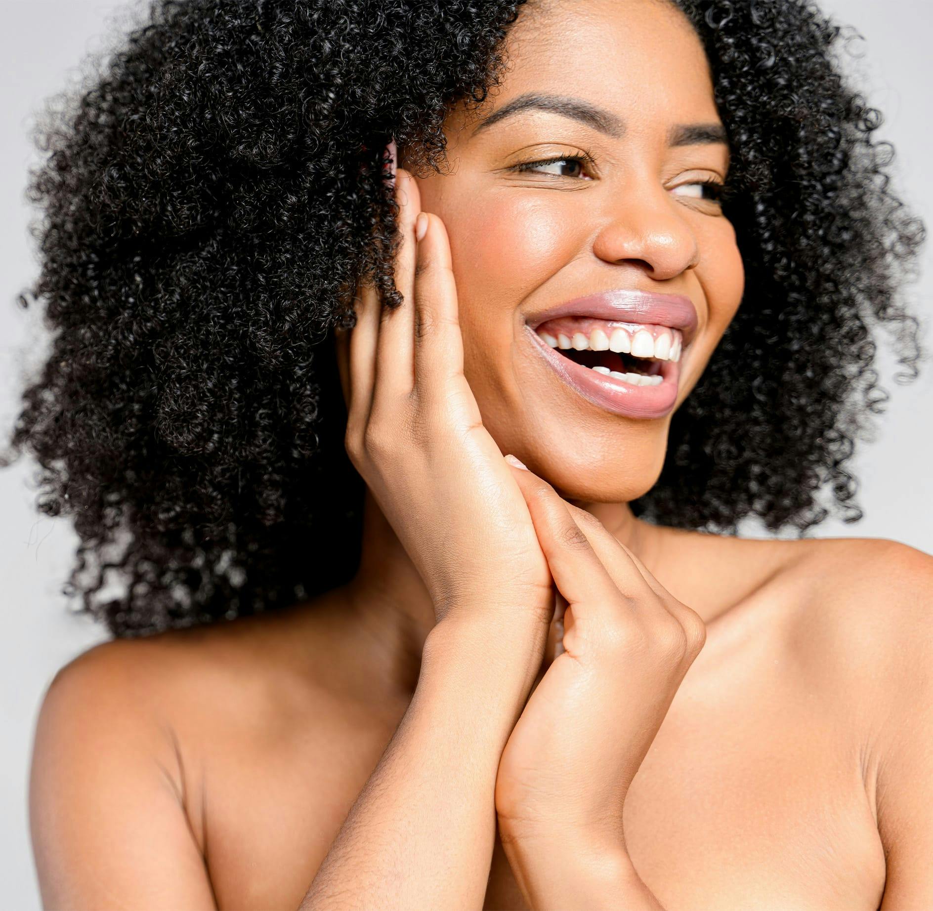 Woman smiling with hands on cheek