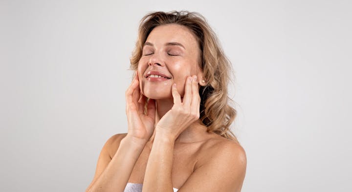 Woman smiling while holding cheeks