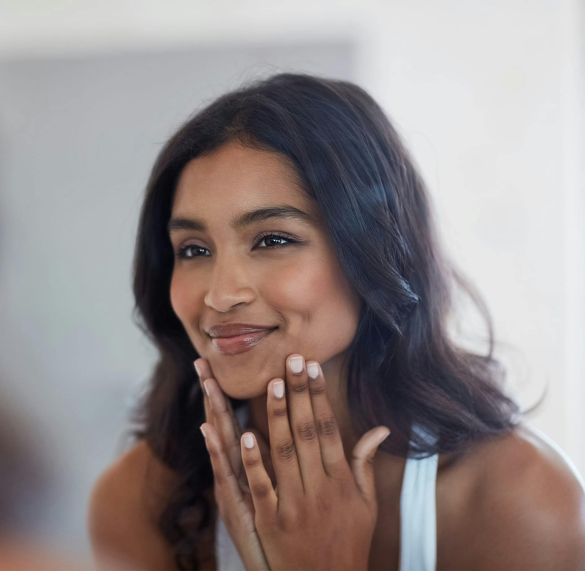 woman touching her face and smirking