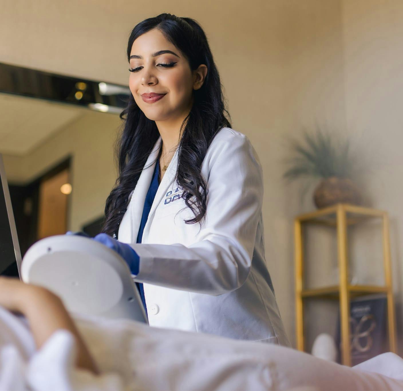 staff member placing emsculpt machine on patient