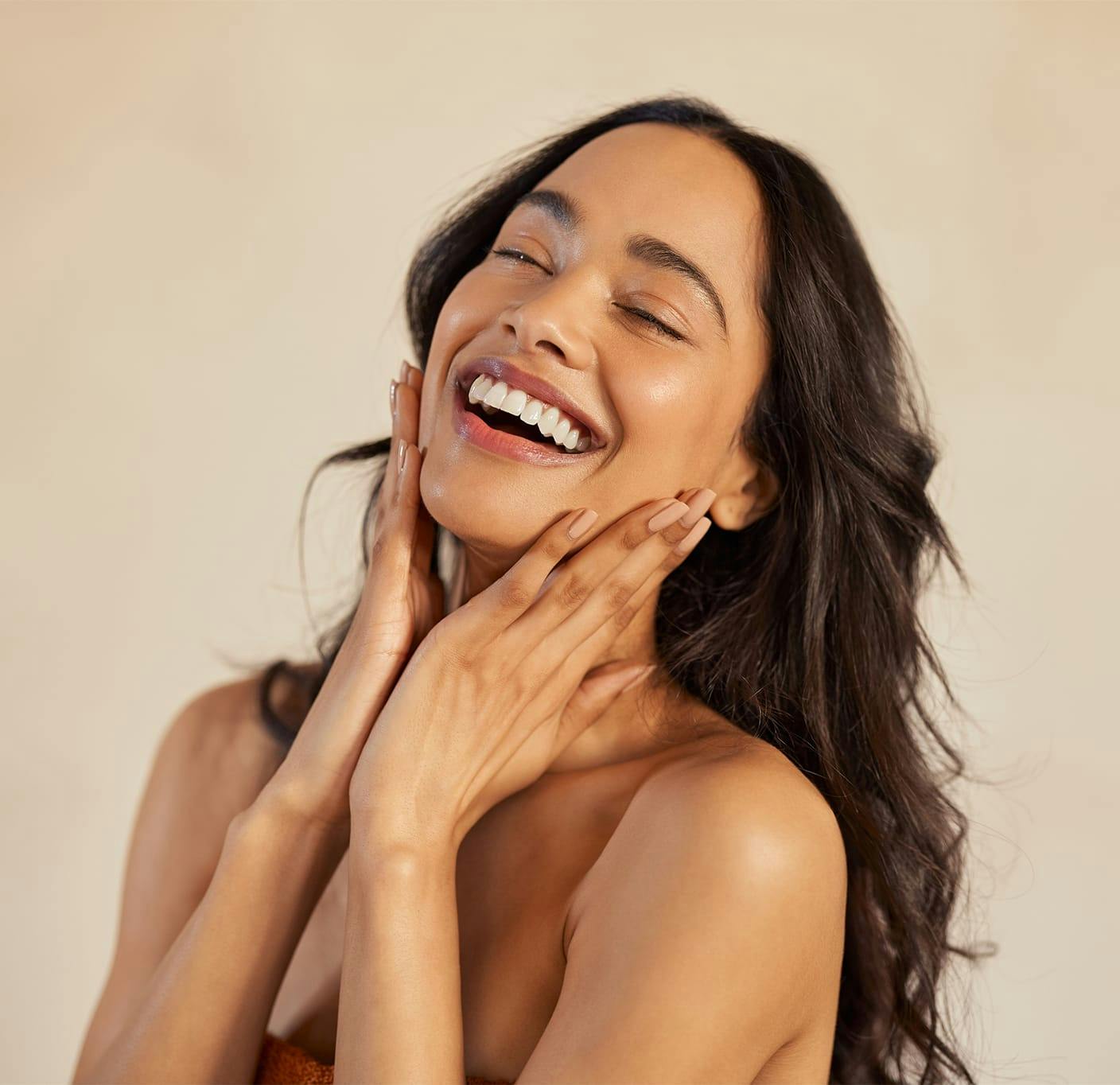 woman smiling with her hands on her face