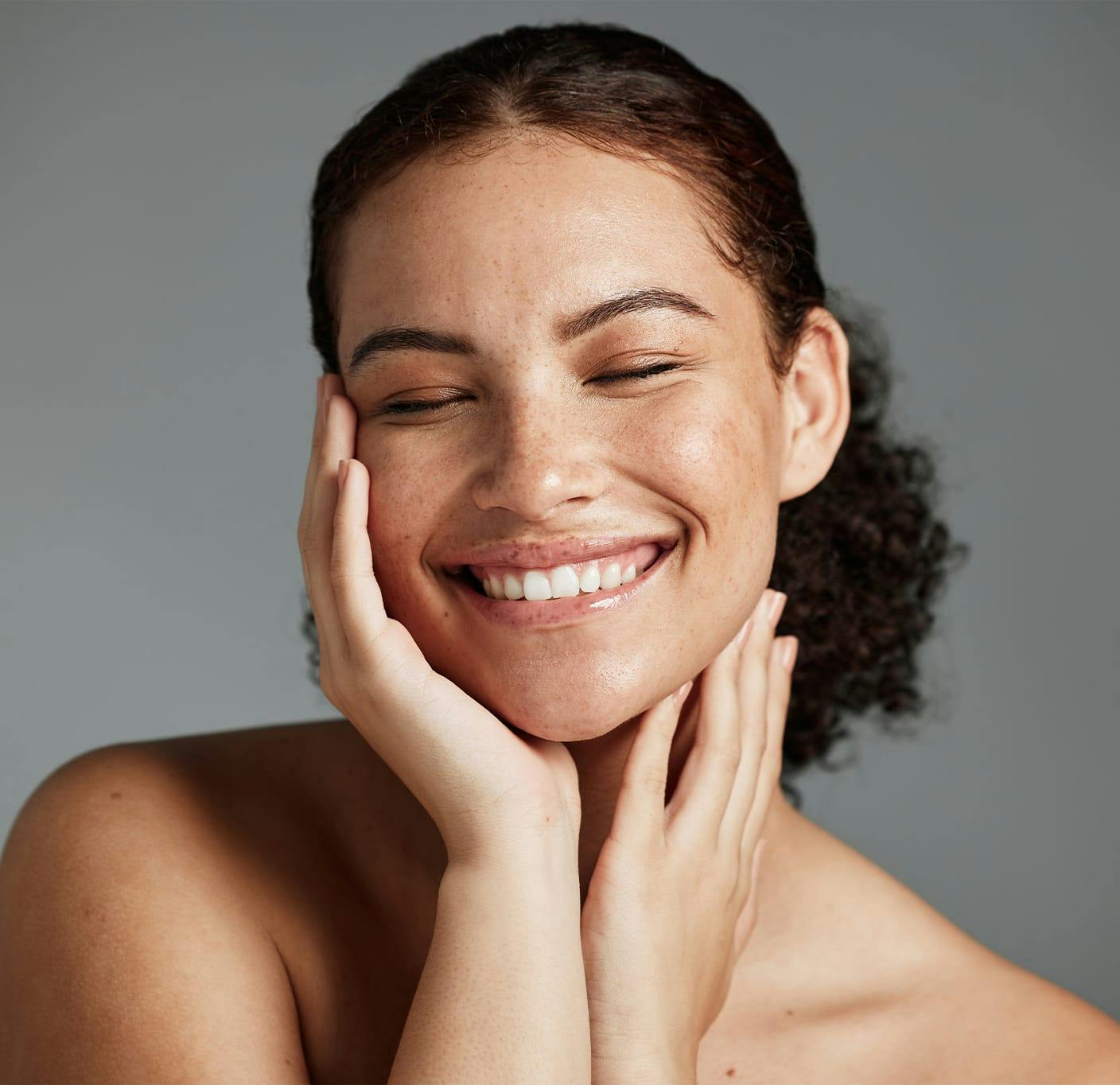 woman smiling with her hands on her face