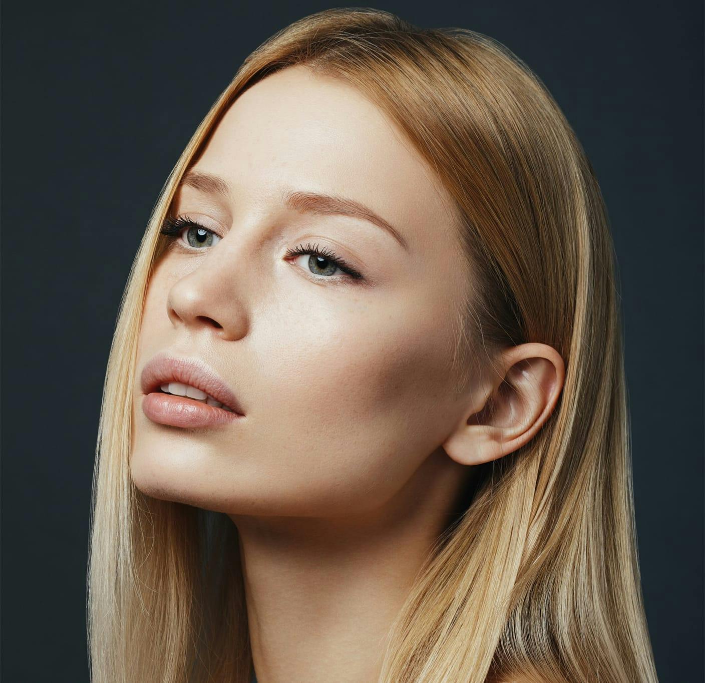 Blonde woman posing against black backdrop