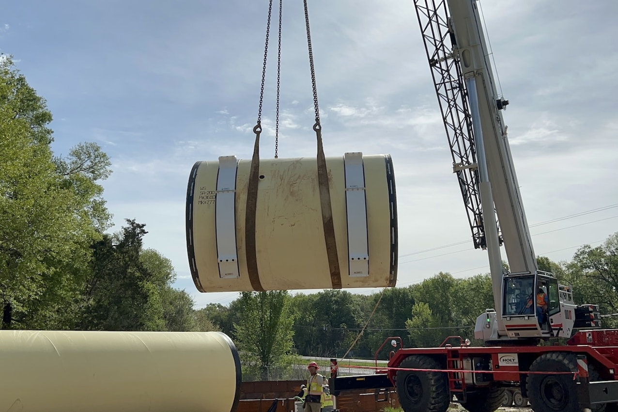 Large pipe being placed into location by crane