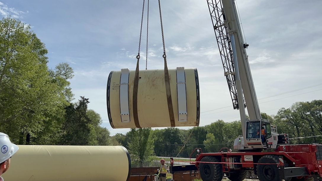 Large pipe being placed into location by crane