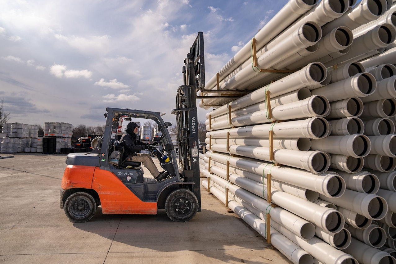 Forklift operator moving stormwater pipe