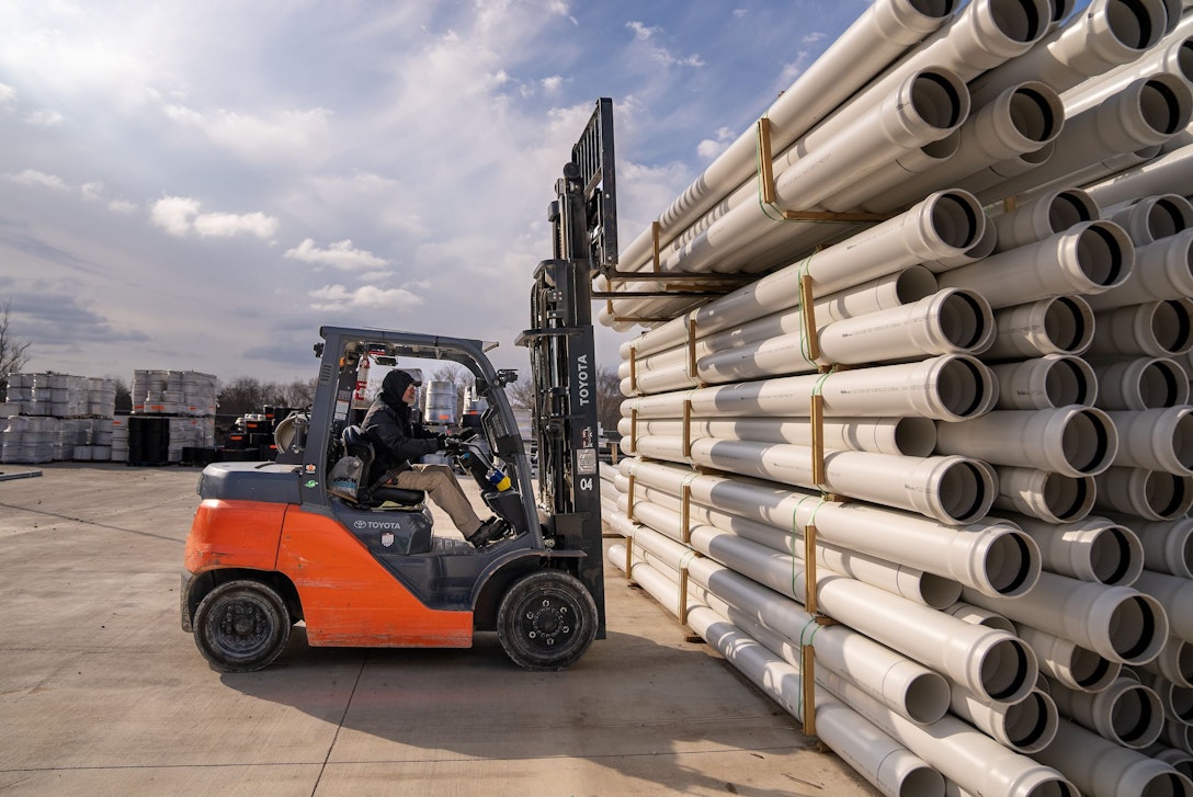 Forklift operator moving stormwater pipe