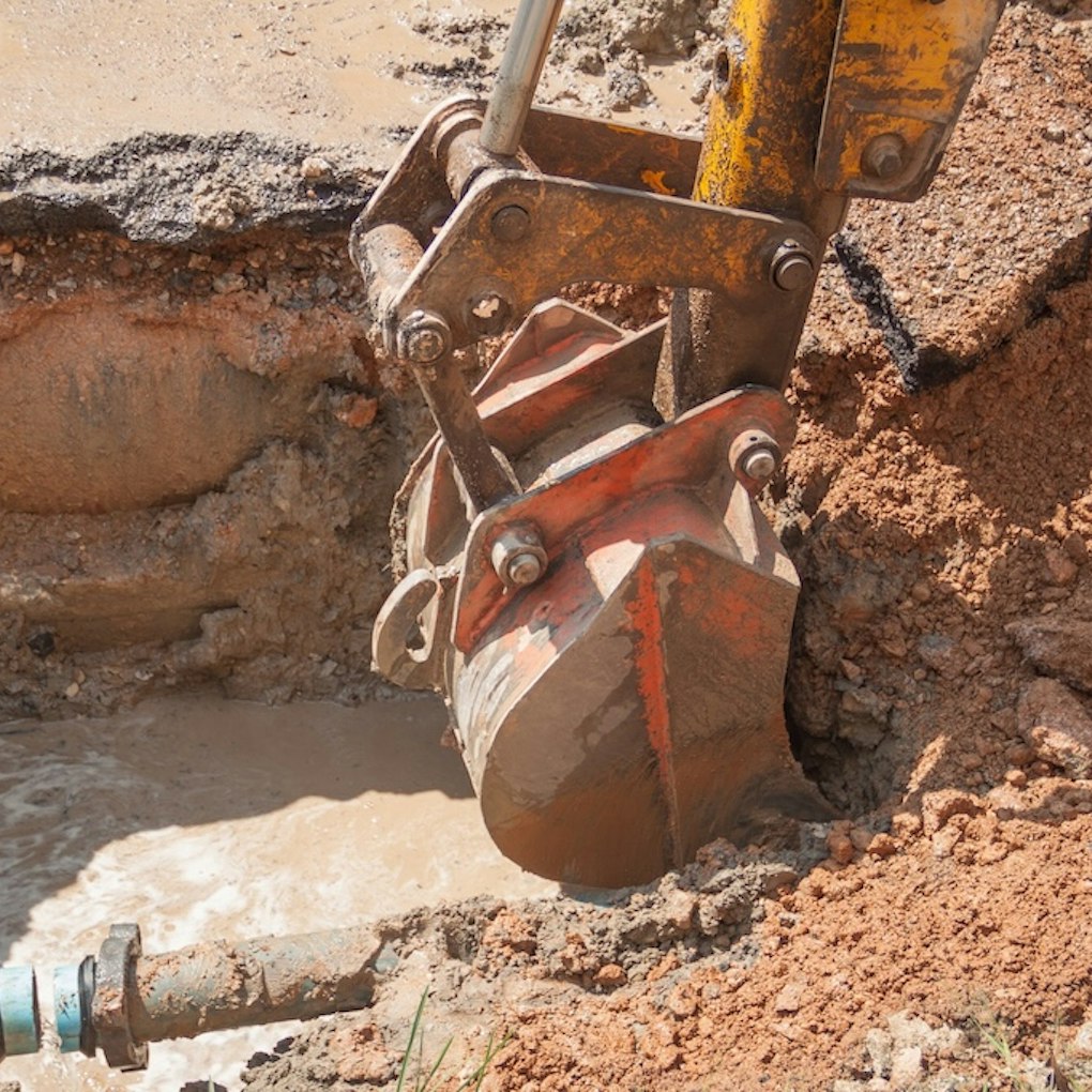 Close-up of excavator head revealing industrial pipe
