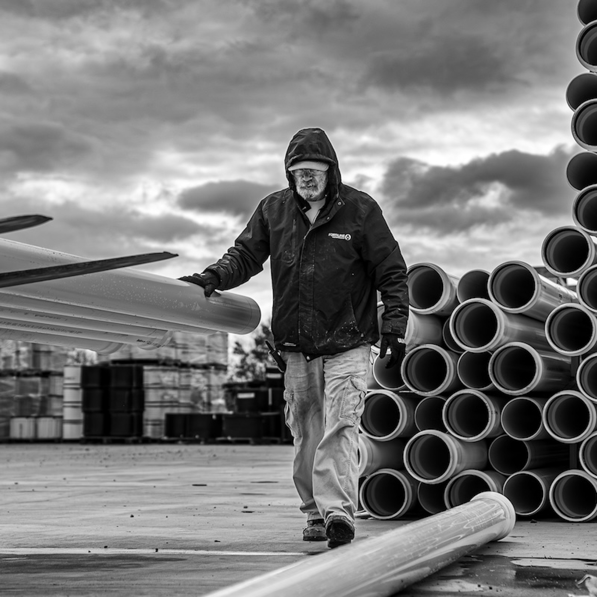 Man on site with stacked pipes