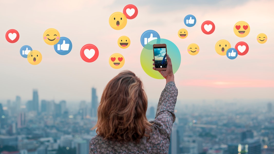 person taking photo with emojis in background