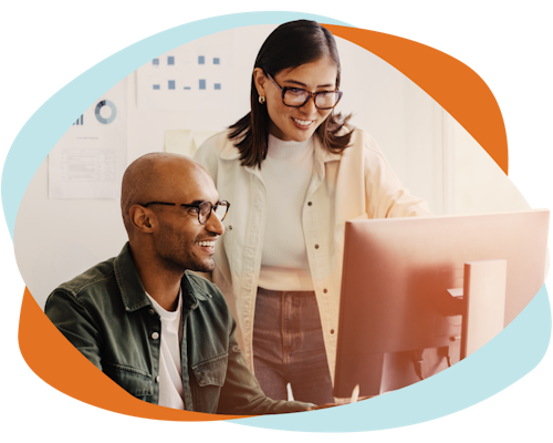 Two underwriters are looking at a computer screen as they use the decision platform automated claims engine software for underwriting teams