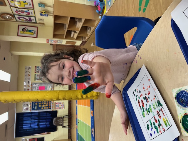 teddy bear surrounded by books, colored pencils, and toys with the words Nursery on Notch Hill on a banner in front