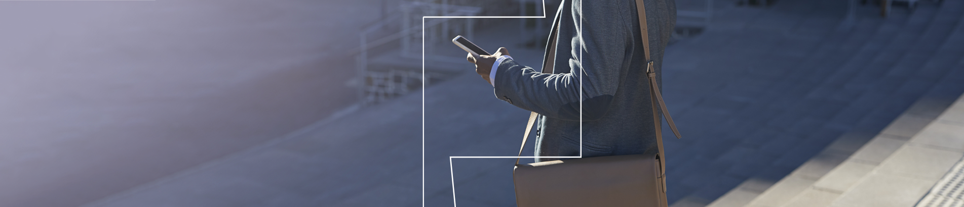 Person with bag and looking at phone on a staircase