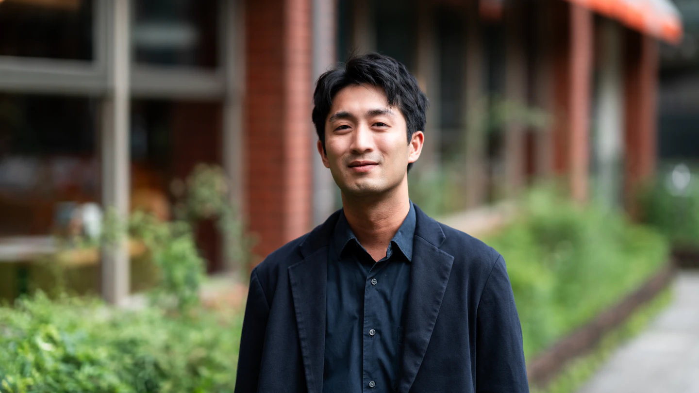 TW - man smiling at camera standing outside an office