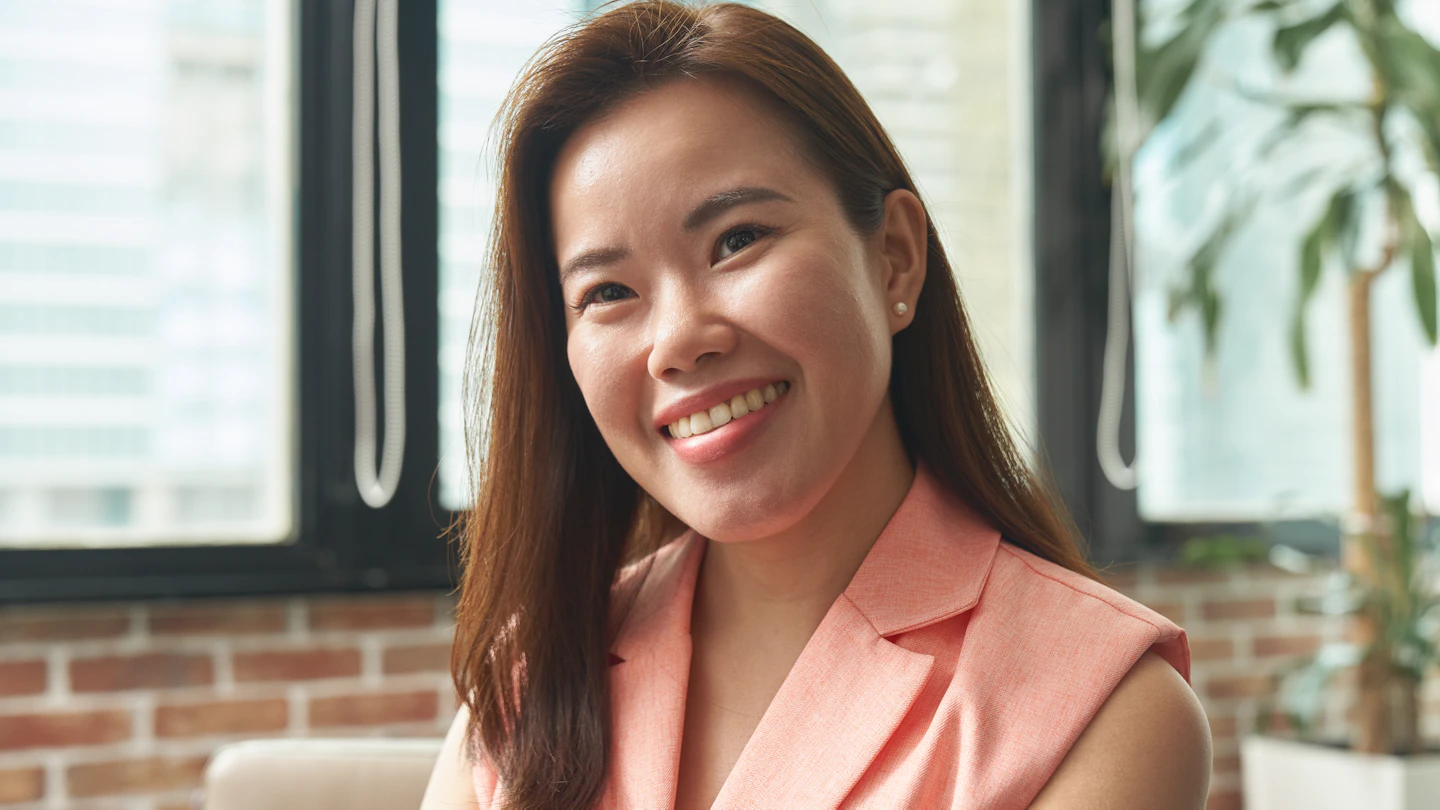 SG - woman in an office smiling at the camera