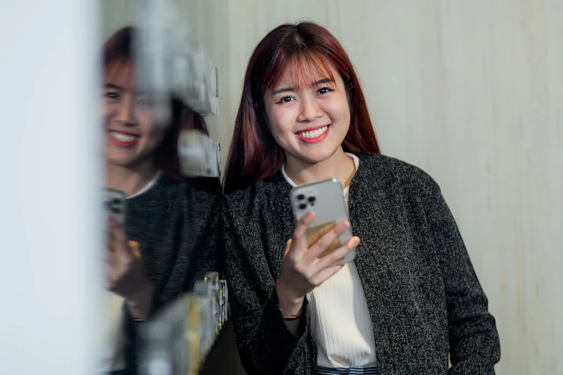 TH - woman holding a phone and smiling