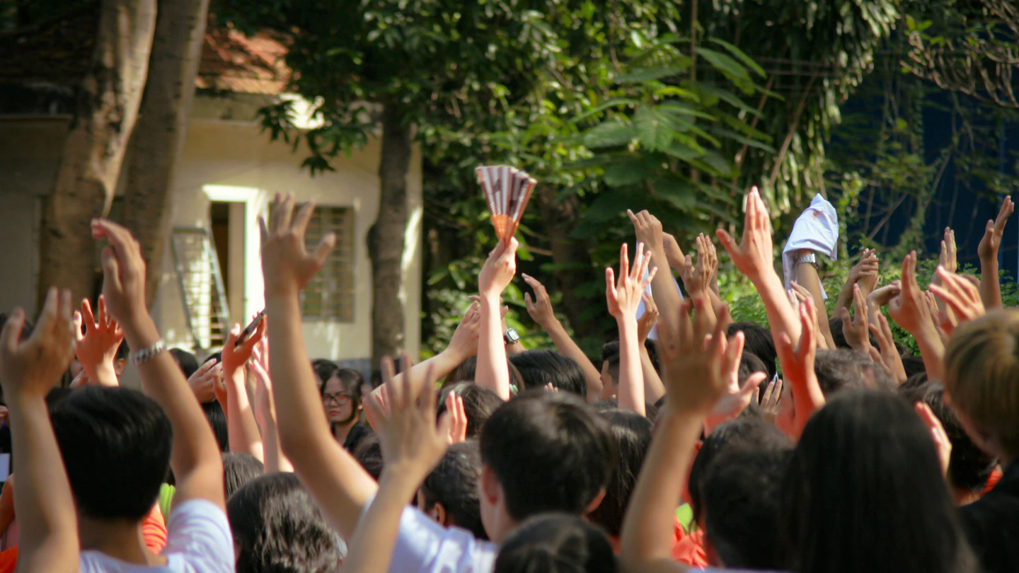 a group of people holding up their hands in the air