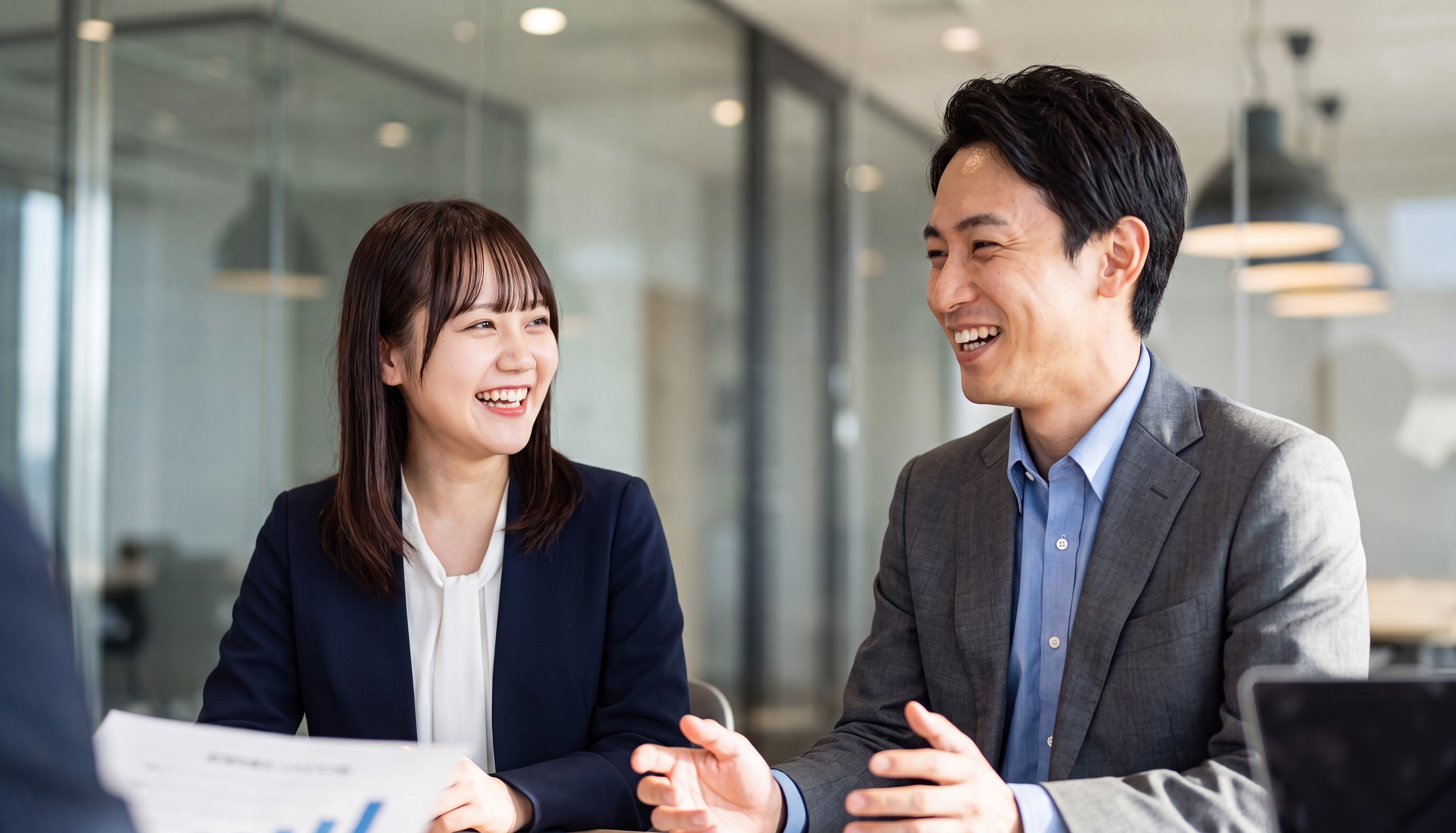 현대적인 사무실에서 회의 중 함께 웃는 일본인 동료들