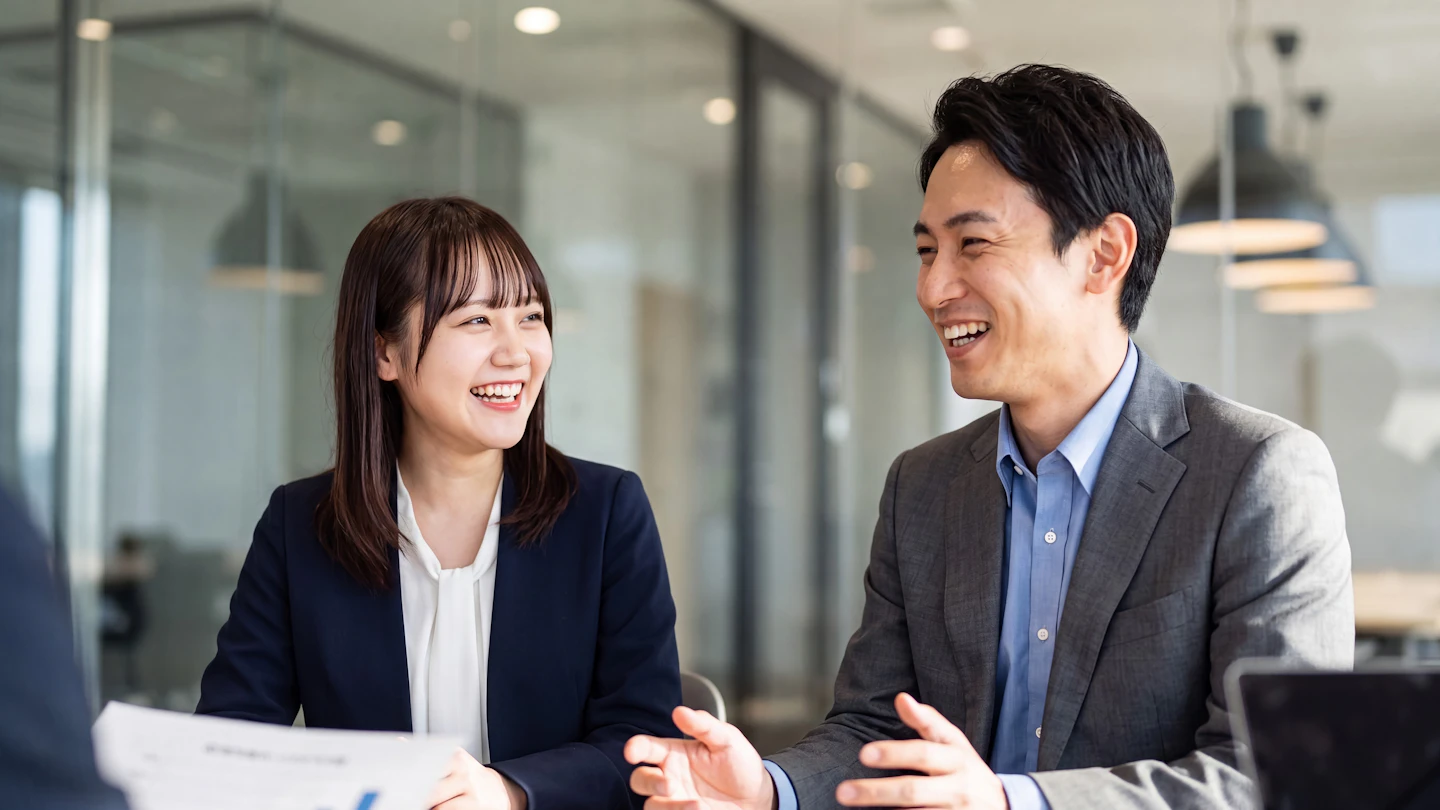 현대적인 사무실에서 회의 중 함께 웃는 일본인 동료들