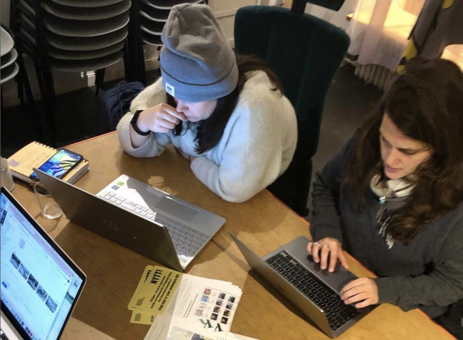 Två konstnärer sitter i mörk mysig miljö med sina bärbara datorer.