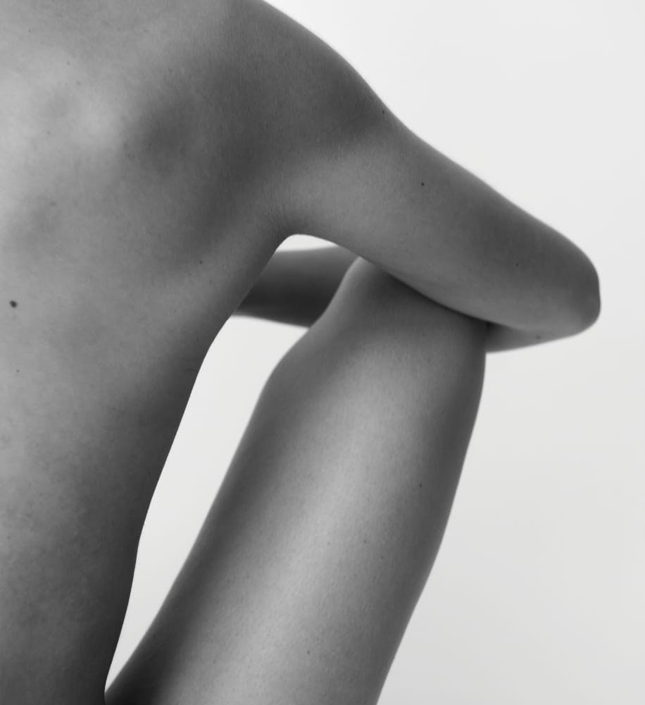 view of woman's back and leg while sitting down naked