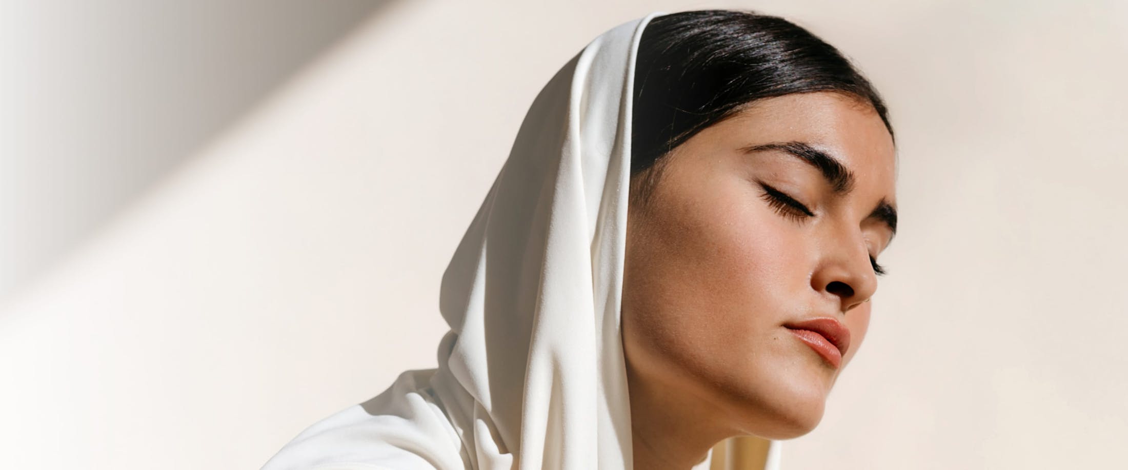 Women with a shawl over head and her eyes closed