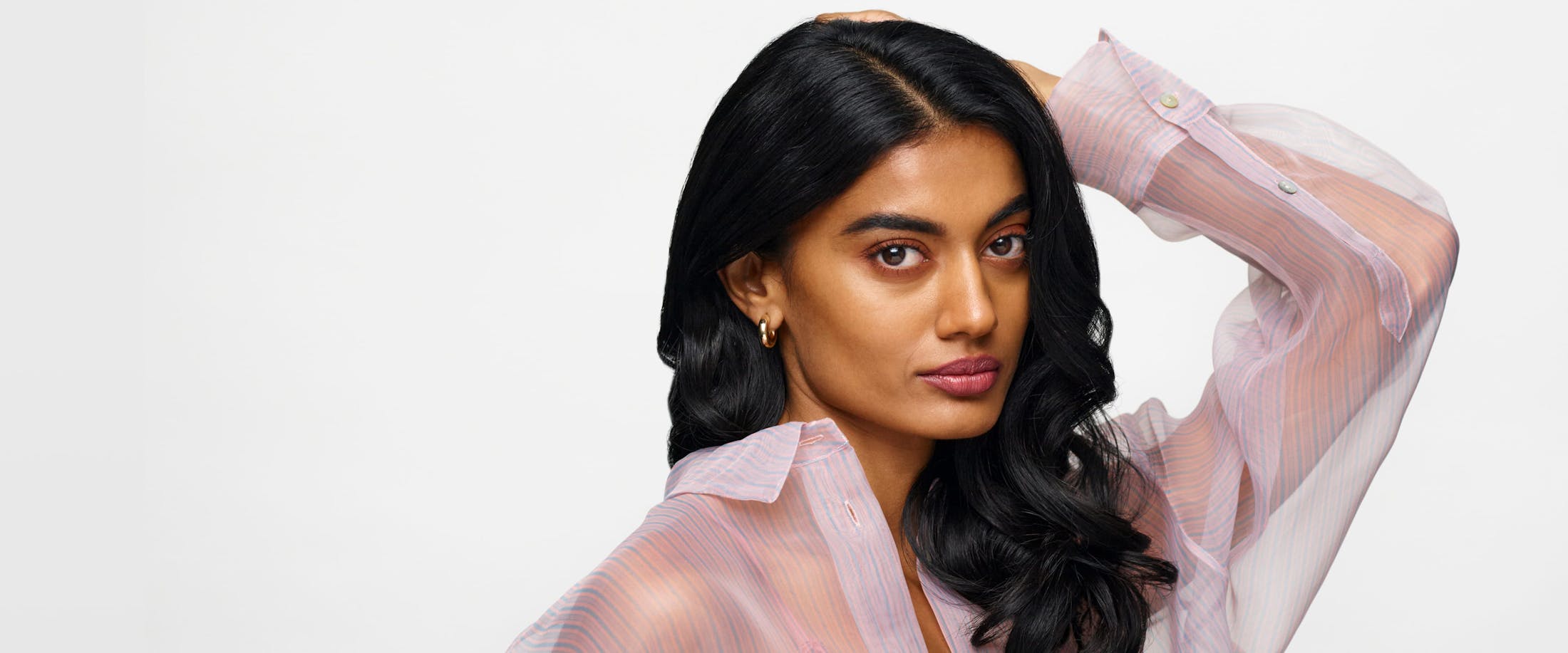 Women with a sheer top and a hand to her head