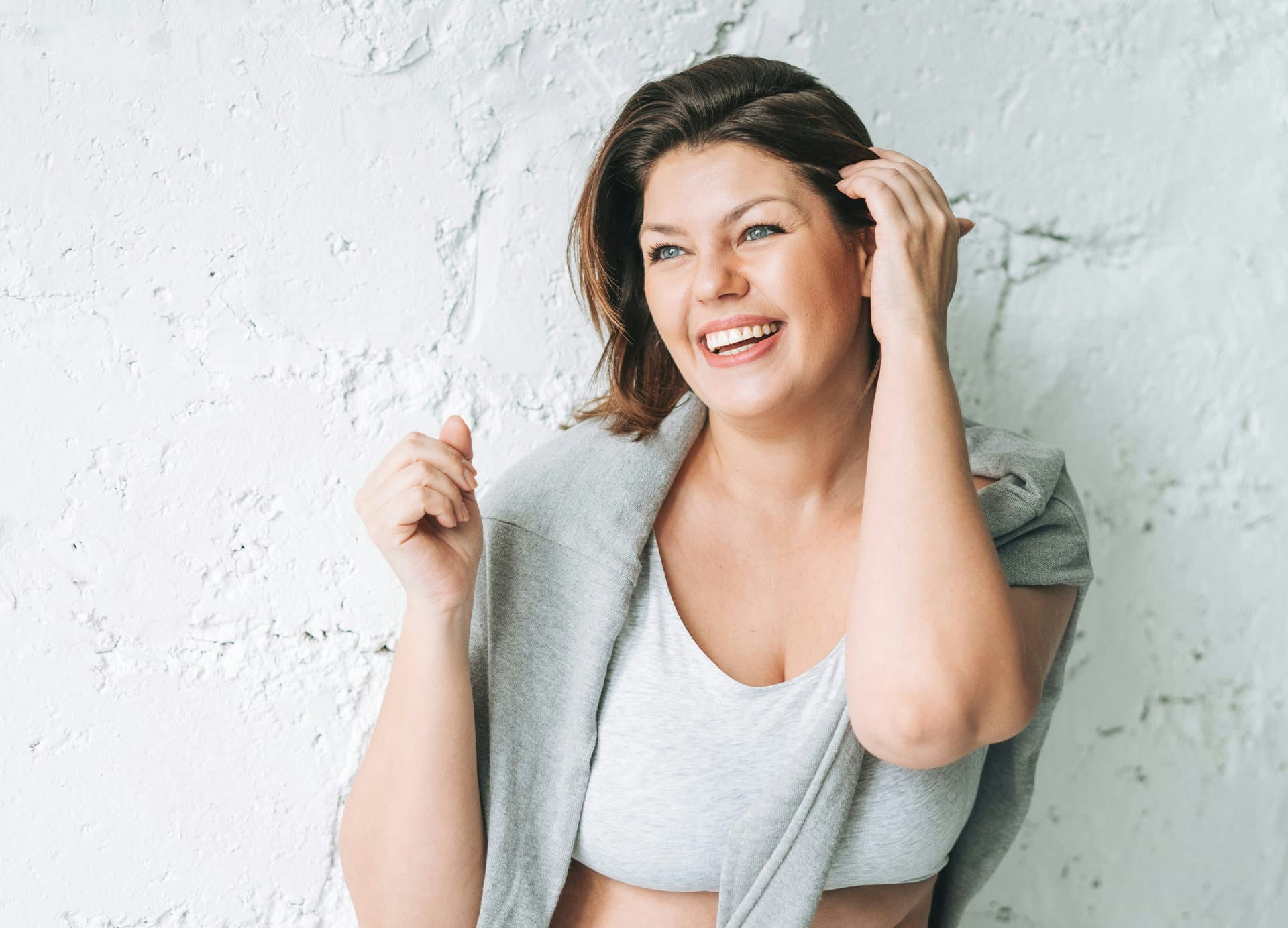 smiling woman with sweatshirt draped over shoulders