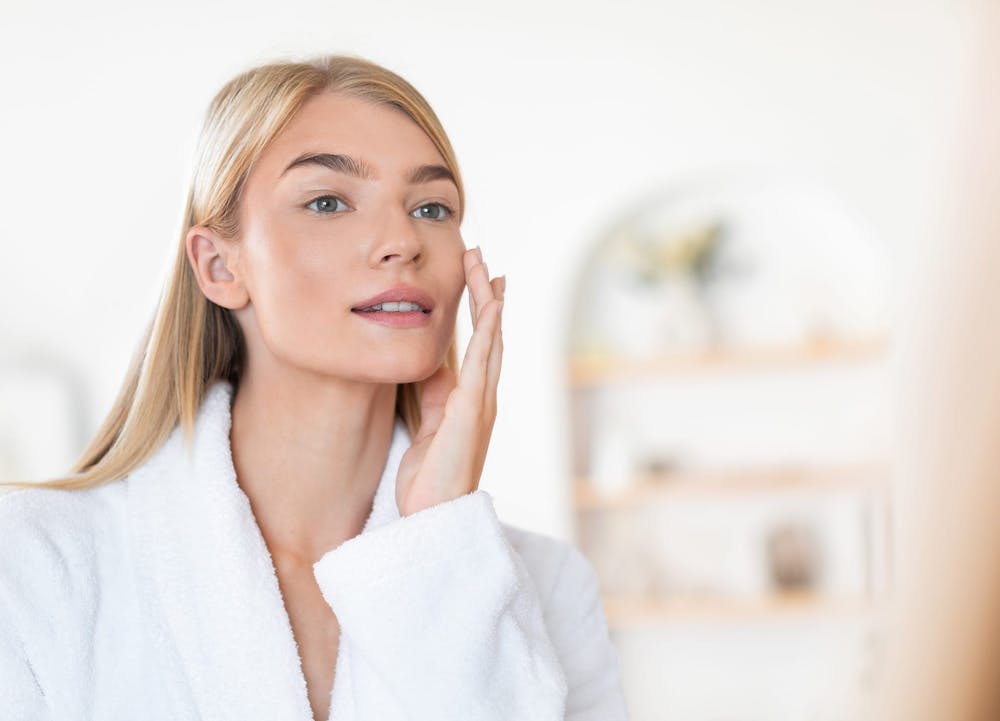 woman in robe touching cheek
