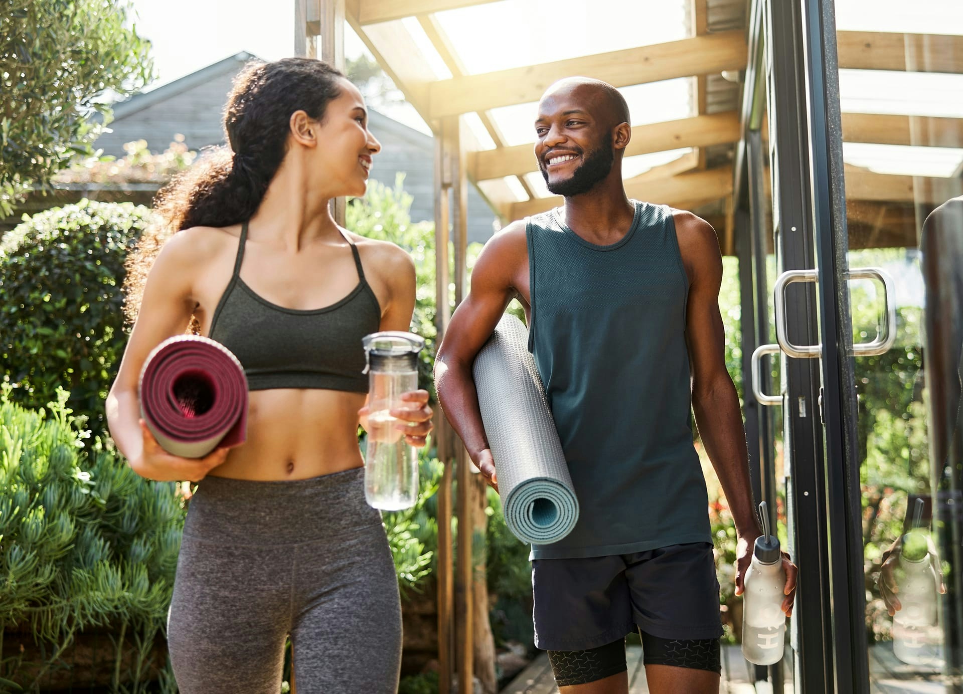 man and woman with yoga mats