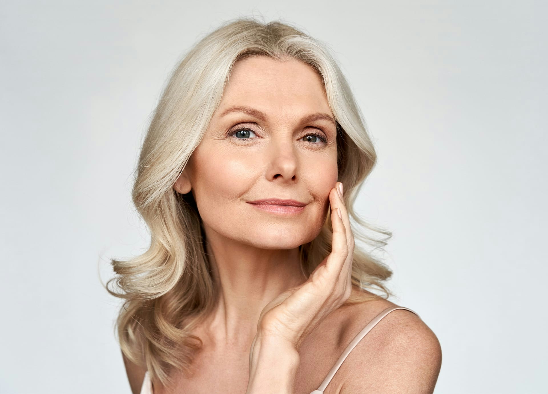 woman smiling and touching cheek