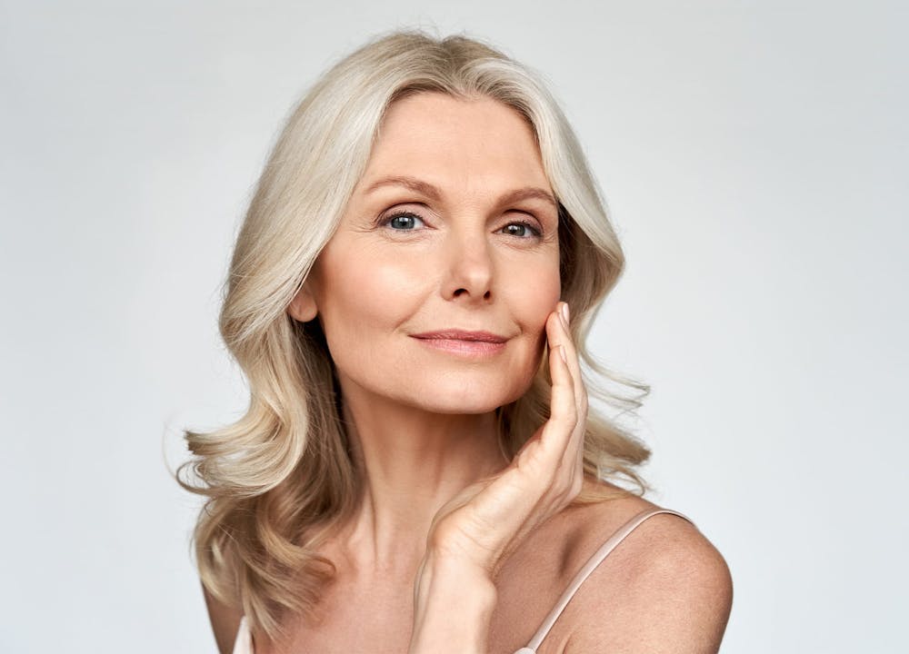 woman smiling and touching cheek