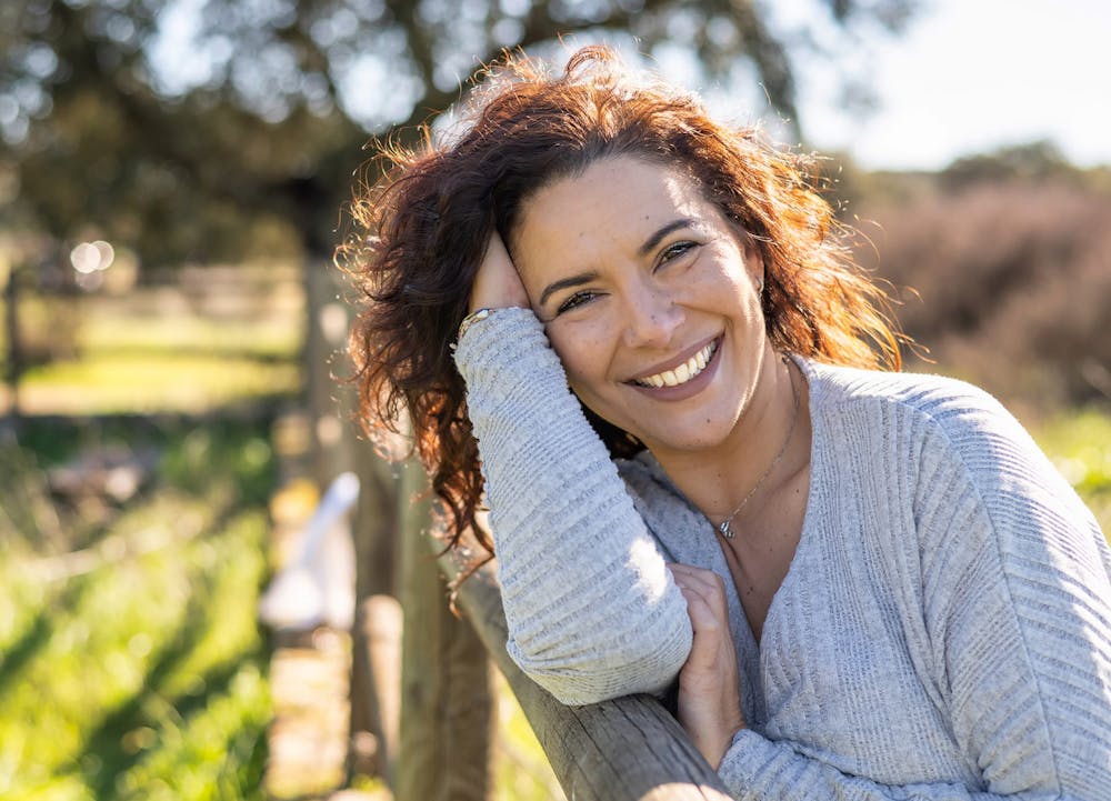 smiling woman resting on fence