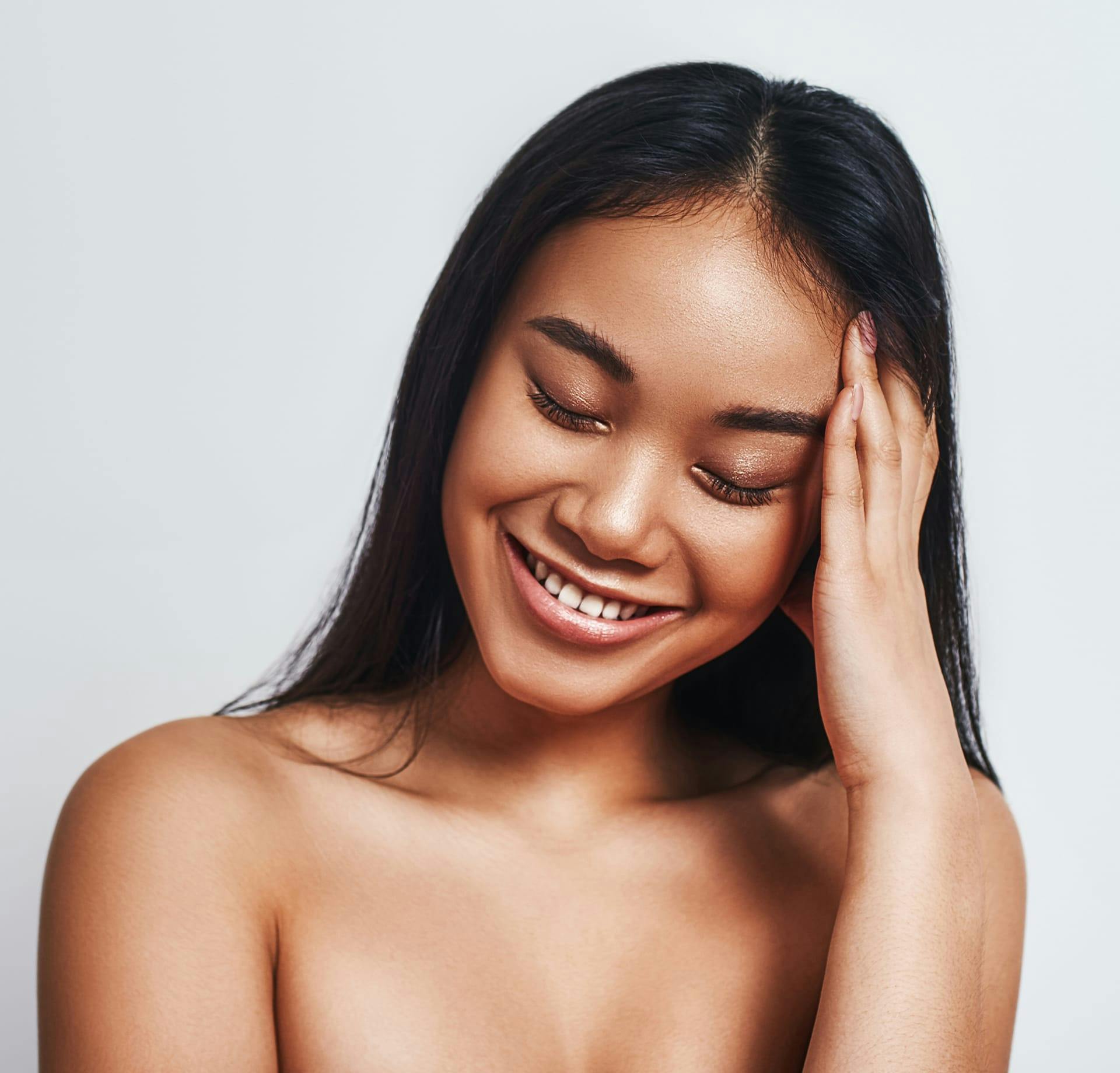 woman smiling and holding head