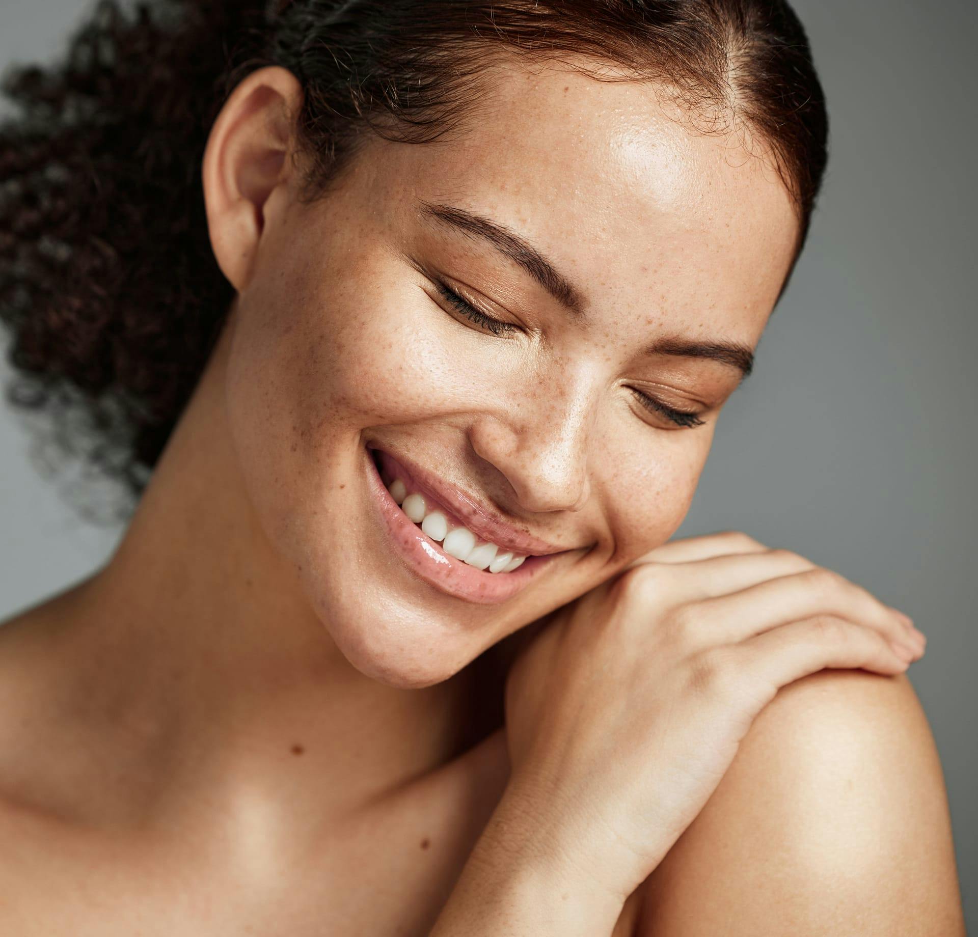 woman smiling with head resting on shoulder