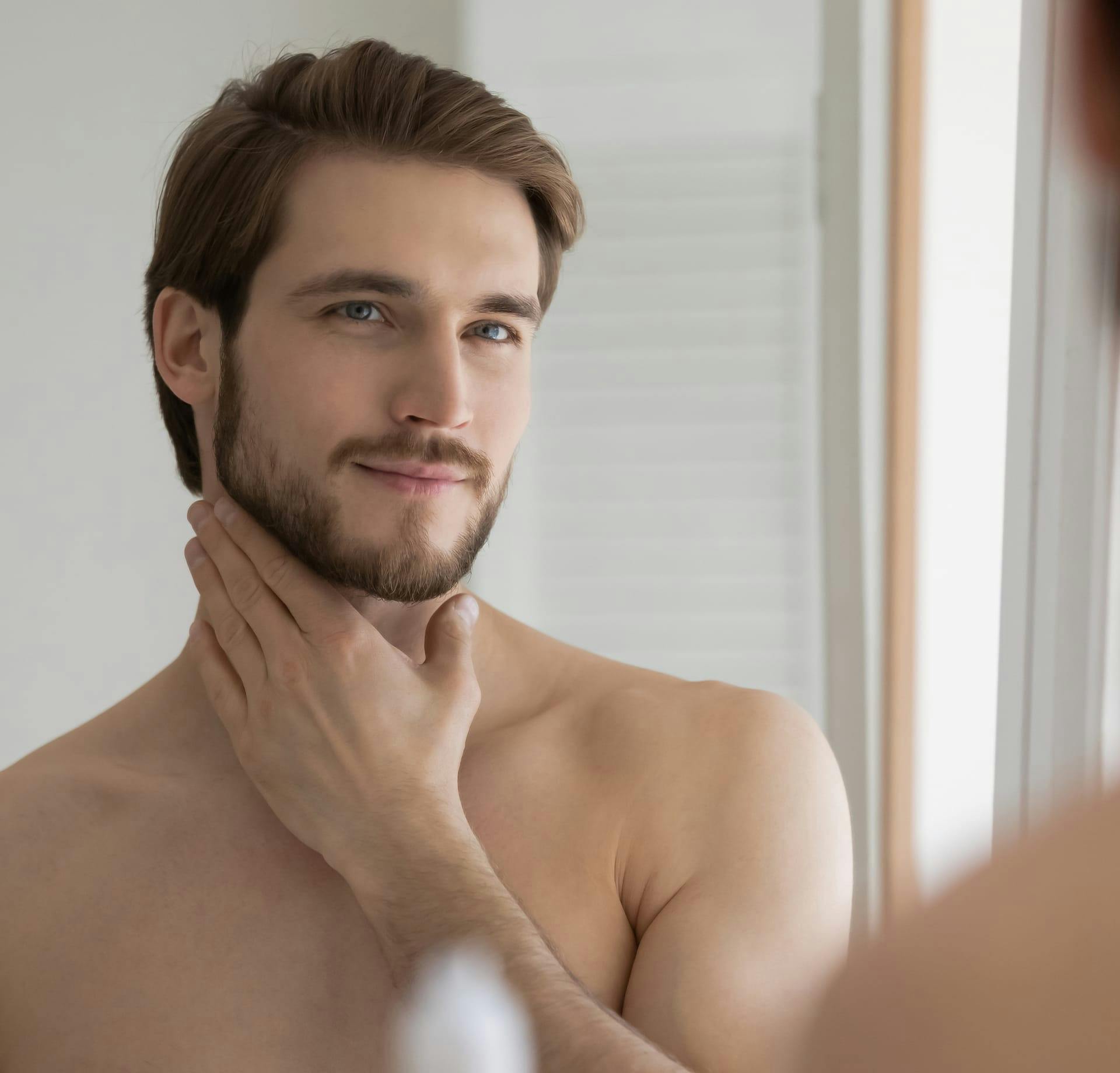 man admiring his beard in the mirror