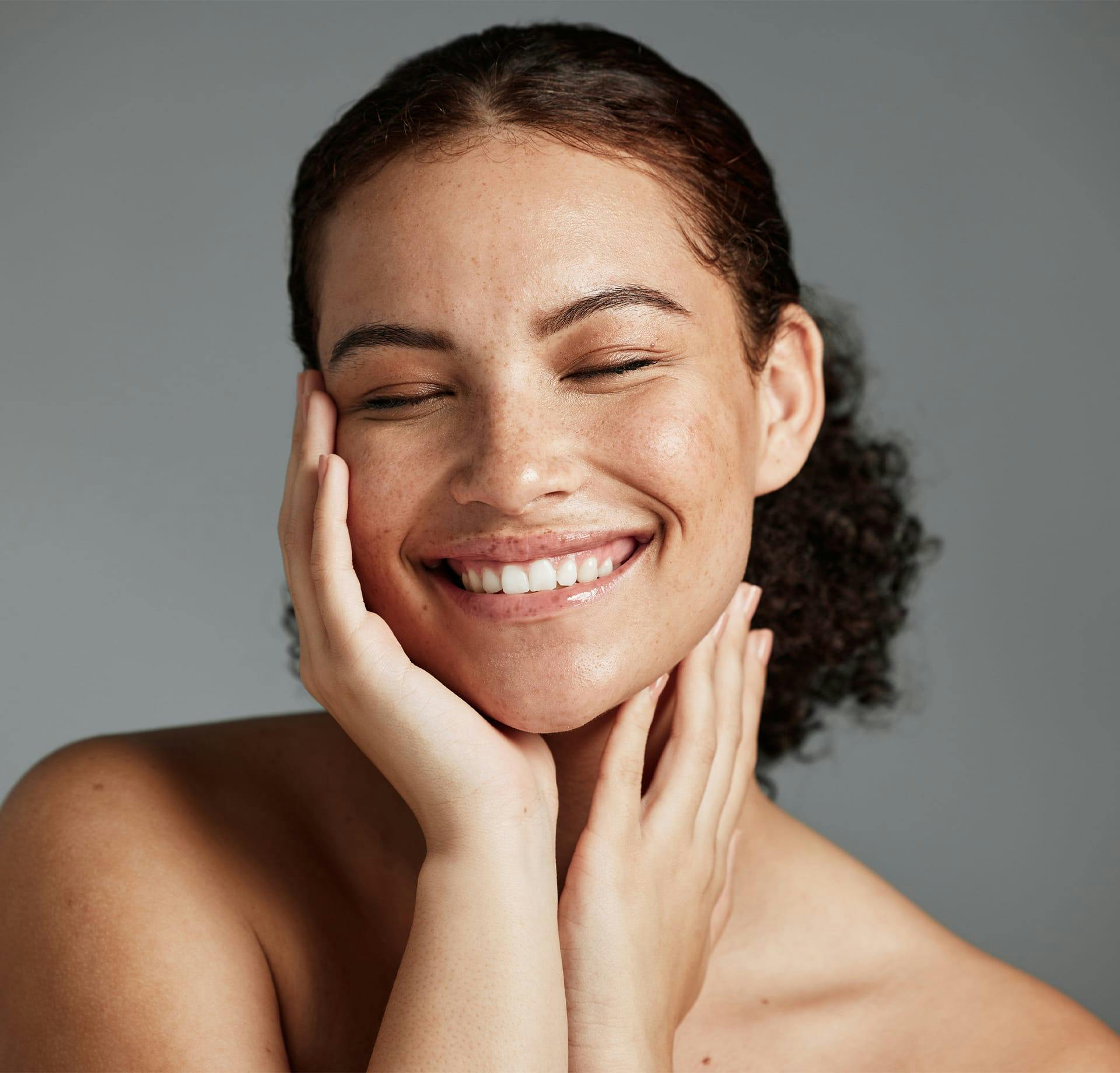 woman smiling and holding cheek